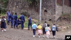 Congo police officers, left rear, are seen at the scene of a granade explosion on the outskirts of Goma, Democratic Republic of Congo, Nov. 8, 2016.