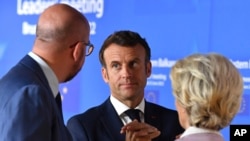 Presiden Prancis Emmanuel Macron berbincang dengan sejumlah pemimpin Eropa sebelum berfoto bersama dengan para pemimpin negara anggota Uni Eropa dalam pertemuan blok tersebut di Brussels, Belgia, pada 23 Juni 2022. (Foto: Pool via AP/John Thys)