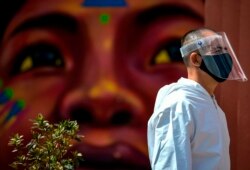 A man wears a face mask and shield in the Chorro de Quevedo tourist area in Bogota, Colombia, on Sept. 3, 2020, amid the novel coronavirus pandemic.