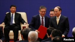 FILE - Vice chairman and president of China Investment Corporations (CIC) Tu Guangshao, chairman of the Board of Directors of the Bank of China Chen Siqing and president of Sinopec Group Dai Houliang attend signing ceremony and meeting of business leaders with U.S. President Donald Trump and China's President Xi Jinping at the Great Hall of the People in Beijing, China, Nov. 9, 2017. 