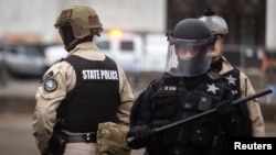 FILE - Police are seen as Oregon State Police and the Salem Police Department declared an "unlawful assembly" during a rally in Salem, Oregon, March 28, 2021. 