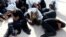 FILE - Migrants sit at a naval base after being rescued by Libyan coast guards, in Tripoli, Libya, June 18, 2018. Libya's navy said Friday it rescued 213 migrants off the Mediterranean coast.
