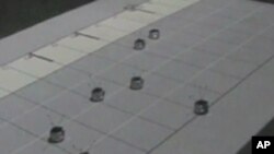Grupa majušnih robota na univerzitetu Georgia Tech "svira" Betovenovu melodiju "Za Elizu" na slici klavijature projektovanoj na podu