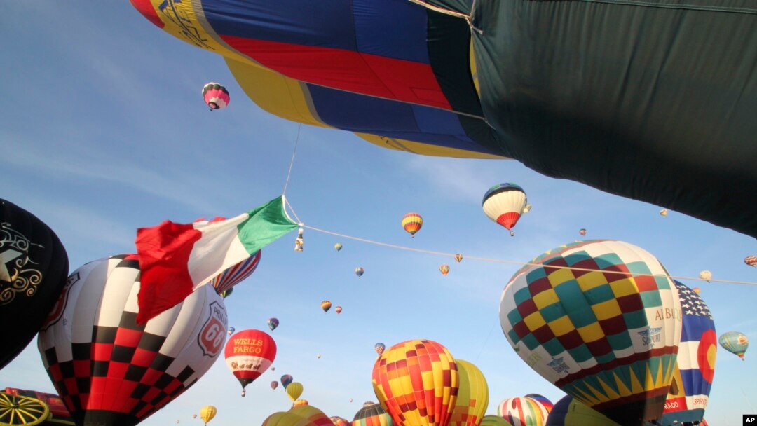FILE - Thousands of spectators mingle among inflating hot air balloons at the 40th Albuquerque International Balloon Fiesta in Albuquerque, N.M., Oct. 2, 2011.