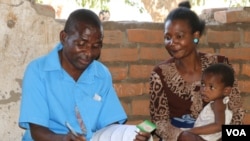 A community health worker at Mwikala district in southern Malawi, attends to a patient. Mwikala, home to over 12,000 people, has become a model village for combating malaria. (Lameck Masina/VOA)