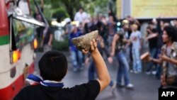 Thai opposition protesters attack a bus carrying pro-government Red Shirt supporters on their way to a rally at a stadium in Bangkok, Nov. 30, 201