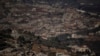 FILE - Destroyed buildings in an area of the village of Odaisseh, in the foreground, backdropped by Kfar Kila, in southern Lebanon, located next to the Israeli-Lebanese border, as seen from northern Israel, Dec. 1, 2024. 