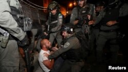 A Palestinian protester is detained during clashes with Israeli police, as the Muslim holy fasting month of Ramadan continues, in Jerusalem, April 23, 2021.
