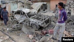Residents inspect a damaged vehicle at the site of a bomb attack in Kirkuk, 250 km (155 miles) north of Baghdad, March 29, 2013. 