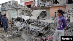 Residents inspect a damaged vehicle at the site of a bomb attack in Kirkuk, 250 km (155 miles) north of Baghdad, March 29, 2013. 