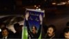 Pakistani lawyers hold up a poster of Supreme Court Chief Justice Iftikhar Muhammad Chaudhry as they mark his retirement outside the Supreme Court building in Islamabad, Dec. 11, 2013.