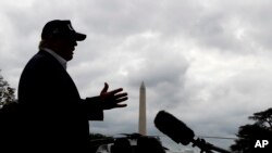 With cloudy skies in Washington, President Donald Trump speaks to the media as he returns to the White House from Camp David, Sunday, Sept. 1, 2019, in Washington.