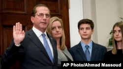 Health and Human Services Secretary Alex Azar, left, accompanied by his family, is sworn in during a ceremony in the Roosevelt Room at the White House, Jan. 29, 2018, in Washington.