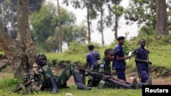 M23 rebel fighters guard the venue of a news conference by political leader Jean-Marie Runiga in north Kivu province near the border with Uganda, July 21, 2012.