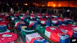 In this handout photo released by Pakistan's Police Department, security officials gather for funeral prayers of police officer, who were killed in the suicide bombing inside a mosque, in Peshawar, Pakistan, Monday, Jan. 30, 2023. A suicide bomber struck Monday inside a mosque in the northwestern Pakistani city of Peshawar, killing multiple people and wounding scores of worshippers, officials said. (Pakistan's Police Department via AP)