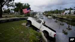 Una camioneta con una bandera estadounidense atada se encuentra a medio camino de un canal en Horseshoe Beach, Florida, después del paso del huracán Idalia, el 30 de agosto de 2023.