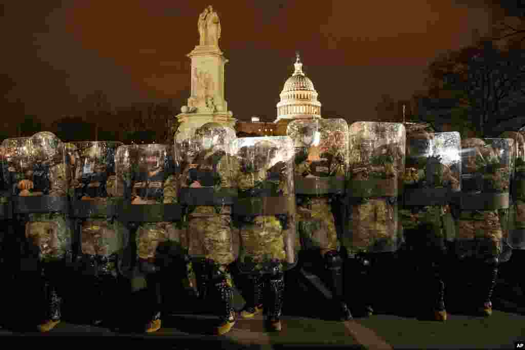 A Guarda Nacional do Distrito de Colúmbia do lado de fora do Capitólio, na noite de quarta-feira, 6 de janeiro de 2021, após um dia de protestos rebeldes. Foi um dia impressionante, pois vários legisladores e depois a multidão de manifestantes tentaram derrubar a eleição presidencial da América, minar a democracia do país e impedir que o democrata Joe Biden substituísse Trump na Casa Branca.