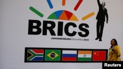 A delegate walks past a BRICS logo ahead of the 10th BRICS Summit, in Sandton, South Africa, July 24, 2018. 