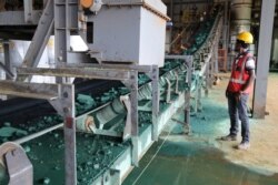 A man watches a conveyor belt loaded with chunks of raw cobalt after a first transformation at a plant in Lubumbashi, Congo, on Feb. 16, 2018, before being exported, mainly to China, to be refined.