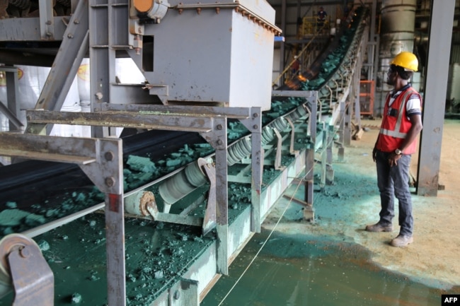 A man watches a conveyor belt loaded with chunks of raw cobalt after a first transformation at a plant in Lubumbashi, Congo, on Feb. 16, 2018, before being exported, mainly to China, to be refined. (Photo by SAMIR TOUNSI / AFP)