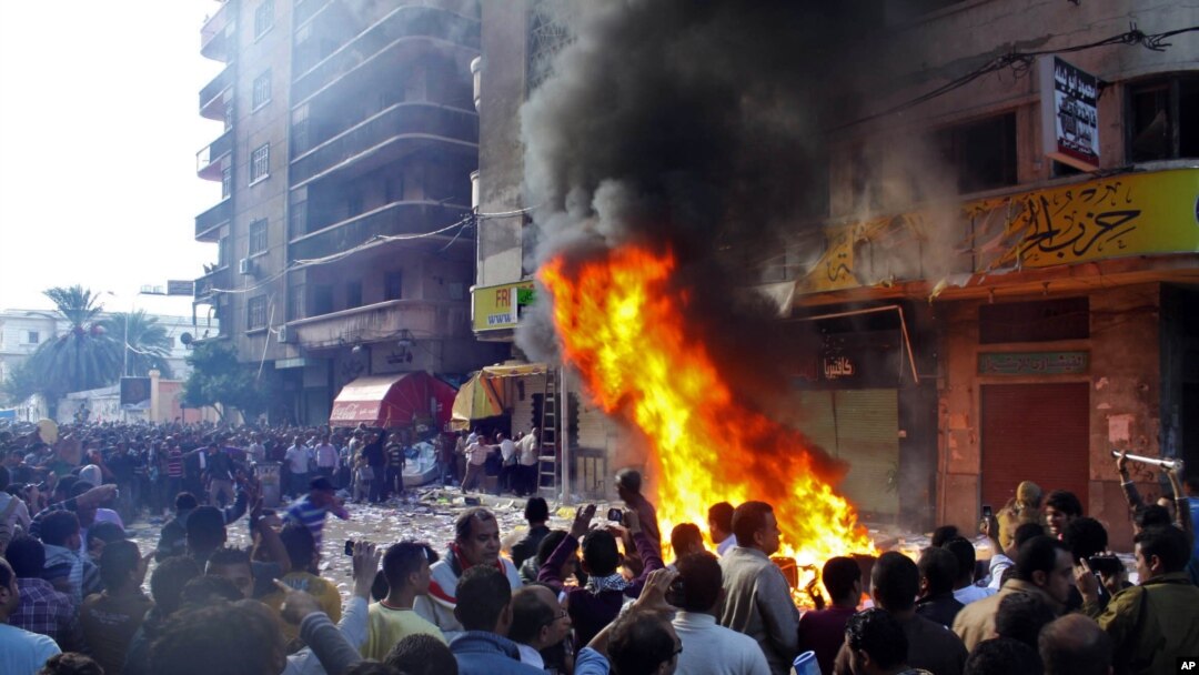Para pengunjuk rasa menyerang sebuah kantor partai Ikhwanul Muslimin di Alexandria (23/11). Para hakim di wilayah ini ikut serta melancarkan aksi protes atas dekrit Presiden Morsi yang dianggap menyerang otoritas independensi peradilan di Mesir.