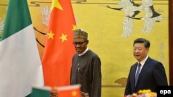 Le président nigérian, Muhammadu Buhari (à g.), son homologue chinois Xi Jinping s'apprêtent à assister à une cérémonie de signature au Grand Hall du Peuple, à Beijing, Chine, 12 avril 2016. (EPA / KENZABURO FUKUHARA)