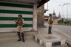 FILE - Indian paramilitary soldiers stand guard at a market in Srinagar, Indian-controlled Kashmir, July 13, 2019.