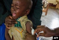FILE - A child reacts as he receives an injection during the nationwide vaccination campaign against measles, rubella and polio targeting all children younger than 15 in Nkozi town, about 84 km from Kampala, Uganda, Oct. 19, 2019.