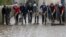 People use shovels and brooms to clean away mud as clean-up operations continue the day after some of the worst flash floods in a century turned rivers into raging torrents that engulfed homes and swept away cars hit the southwestern Aude district of Fran