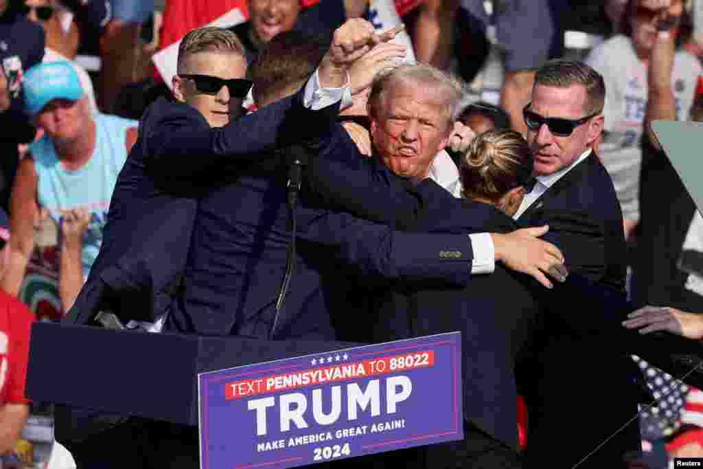 Republican presidential candidate and former U.S. President Donald Trump is assisted by U.S. Secret Service personnel after he was shot in the right ear during a campaign rally at the Butler Farm Show in Butler, Pennsylvania, July 13, 2024.&nbsp;