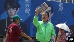 A staff of a Japanese newspaper hands extra edition reporting North Korea's rocket launch at a street corner in Tokyo, Aug. 29, 2017. (AP Photo/Mari Yamaguchi) 