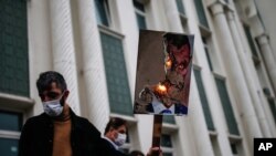 30일 터키 이스탄불에서 프랑스 정부에 항의하는 시위 참가자가 에마뉘엘 마크롱 프랑스 대통령을 악마로 묘사한 캐리커처를 불태우고 있다.