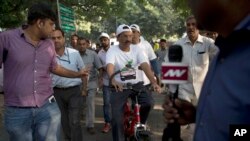 Delhi Chief Minister Arvind Kejriwal (c) takes part in a cycle rally during a car-free day covered only a six-kilometer (4-mile) stretch in New Delhi, India, October 22, 2015.