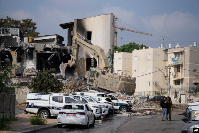 Una excavadora retira los escombros de la comisaría de policía que fue invadida por militantes de Hamás el sábado, en Sderot, Israel, el domingo 8 de octubre de 2023.