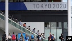 Para jurnalis berkumpul di Kompleks Multifungsi Desa Olimpiade dan Paralimpiade Tokyo 2020 selama kunjungan media di Tokyo, Minggu, 20 Juni 2021. (Foto AP / Eugene Hoshiko)
