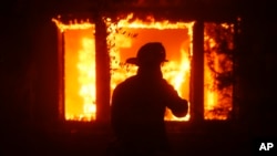 ARCHIVO - La silueta de un bombero puede verse frente a una estructura incendiada en Los Ángeles, el 7 de enero de 2025.