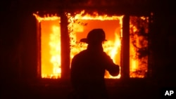 Un bombero observa una estructura en llamas mientras el incendio Palisades arrasa el vecindario Pacific Palisades de Los Ángeles, el martes 7 de enero de 2025. (Foto AP/Etienne Laurent)