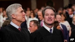 FILE - Supreme Court Associate Justices Neil Gorsuch, left, and Brett Kavanaugh watch as President Donald Trump arrives to give his State of the Union address to a joint session on Congress at the Capitol in Washington. 