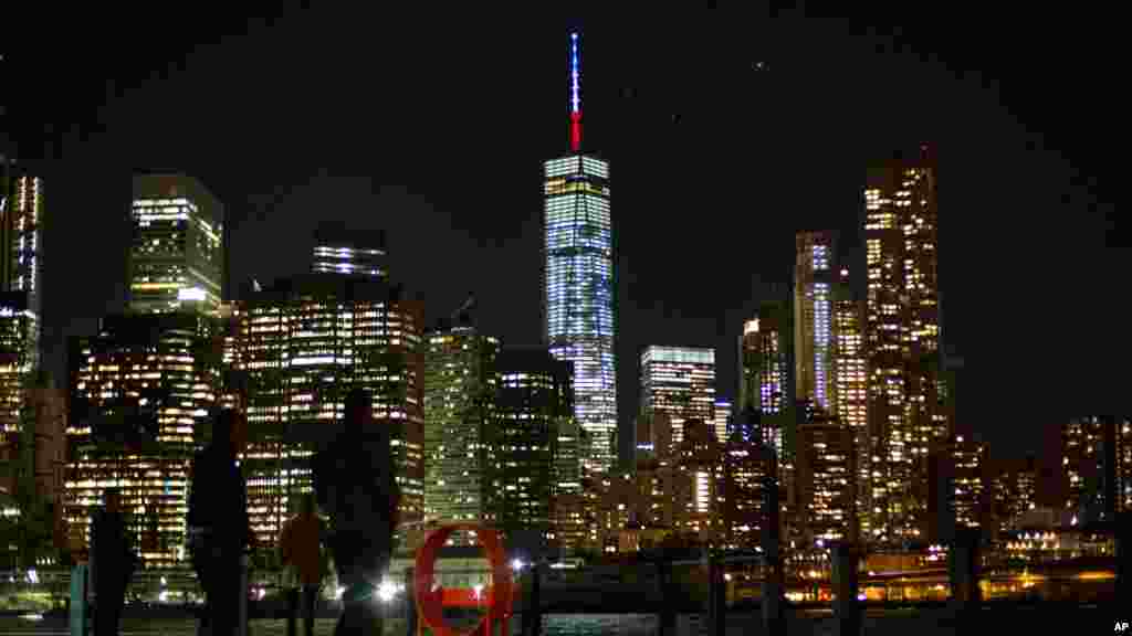 The One World Trade Center spire is lit blue, white and red after New York Gov. Andrew Cuomo announced the lighting in honor of dozens killed in the Paris attacks, Nov. 13, 2015. 