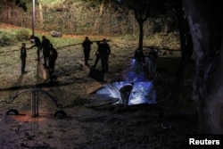 Israeli emergency services work at the scene of a missile strike that, according to Israel's military, was launched from Yemen and landed in Jaffa, south of Tel Aviv, Israel, Dec. 21, 2024.