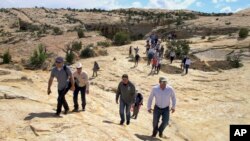 FILE - Utah state legislators and their staff lead the way for Interior Secretary Ryan Zinke, Utah Gov. Gary Herbert and others in the distance, May 8, 2017.