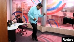 FILE - Venezuela's President Nicolas Maduro dances during his radio program at Miraflores Palace in Caracas, Venezuela.