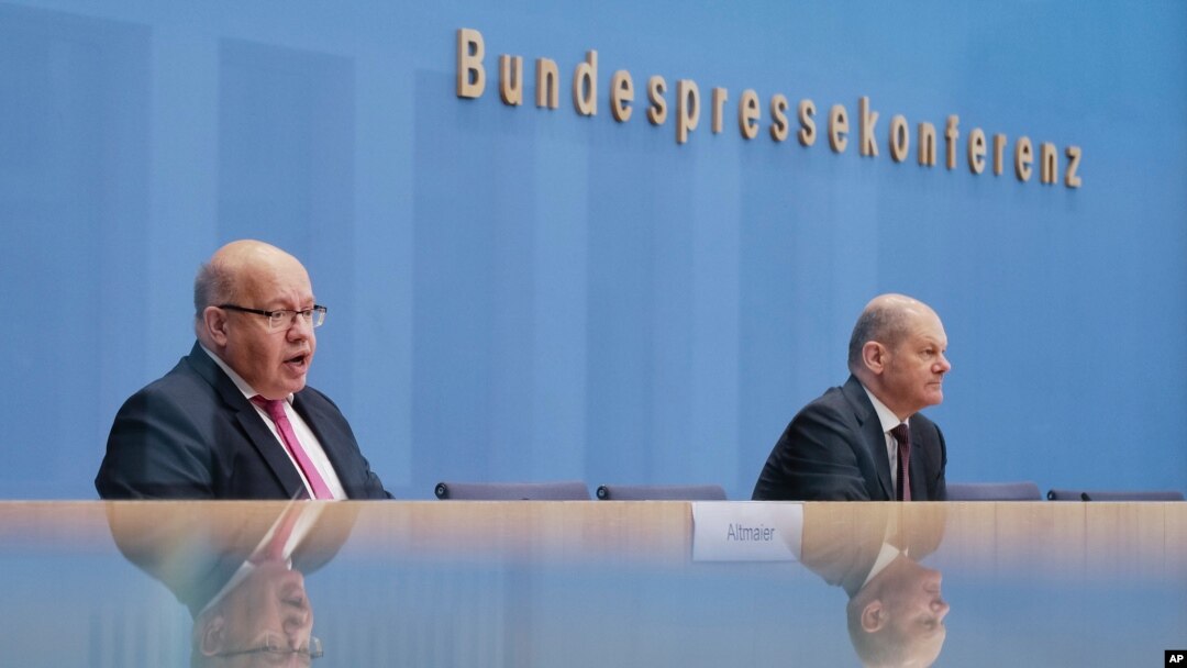 German Economy Minister Peter Altmaier, right, and Finance Minister Olaf Scholz brief the media during a news conference about German economy during the coronavirus crises in Berlin, Germany, Oct. 29, 2020.