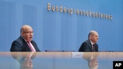 German Economy Minister Peter Altmaier, right, and Finance Minister Olaf Scholz brief the media during a news conference about German economy during the coronavirus crises in Berlin, Germany, Oct. 29, 2020.