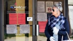 A woman looks to get information about job application in front of IDES (Illinois Department of Employment Security) WorkNet center in Arlington Heights, Ill., April 9, 2020.