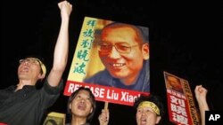Pro-democracy protesters raise pictures of Chinese dissident Liu Xiaobo with Chinese words reading: ‘Release Liu Xiaobo’ during a demonstration outside the China's Liaison Office in Hong Kong, 08 Oct. 2010