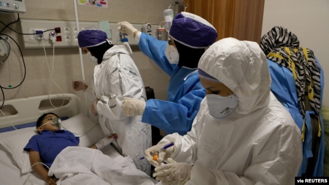 Nurses take a sample from Parham, a 7-year-old, to test for the coronavirus disease (COVID-19), at a hospital, in Tehran, Iran, July 8, 2020. (West Asia News Agency)