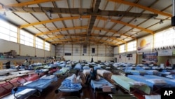 People who fled their homes during wildfires are accommodated at an indoor hall in Chalkida the capital of Evia island, about 81 kilometers (50 miles) north of Athens, Greece, Aug. 7, 2021.