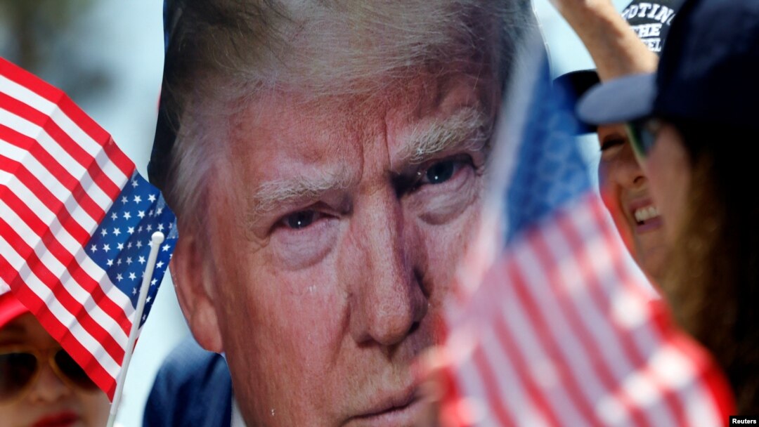Un partidario de Trump sostiene un retrato del expresidente Donald Trump durante una manifestación un día después de que Trump recibiera un disparo en un intento de asesinato durante un mitin en Pensilvania, en Huntington Beach, California, EEUU, el 14 de julio de 2024.