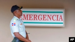 FILE - A police officer stands guard outside a hospital in Santo Domingo, Dominican Republic, June 10, 2019. 